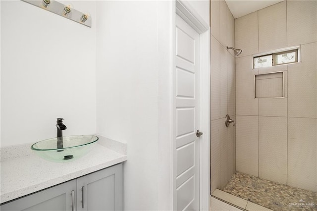 bathroom with vanity and tiled shower