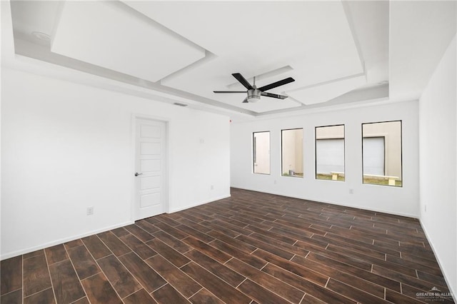 empty room featuring a raised ceiling and ceiling fan