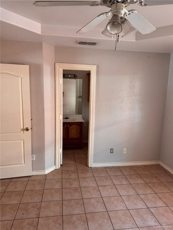 empty room with light tile patterned floors and ceiling fan