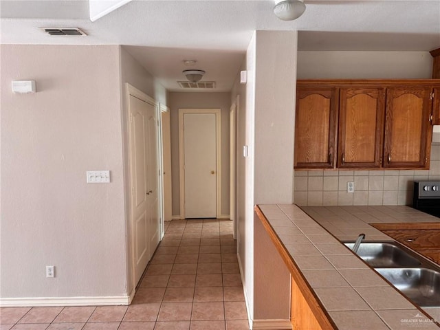 hall with sink and light tile patterned floors