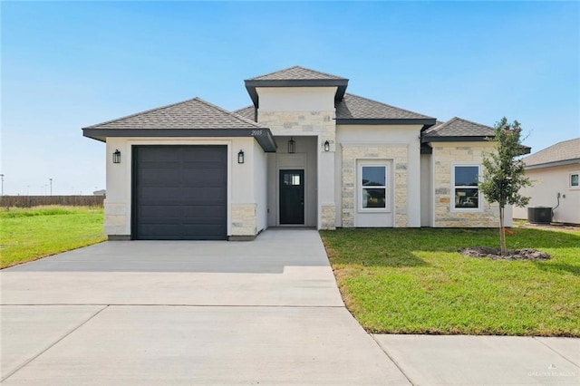 2005 Lime St, San Juan, TX 78589 - prairie-style house with stone siding, concrete driveway, an attached garage, and a front yard