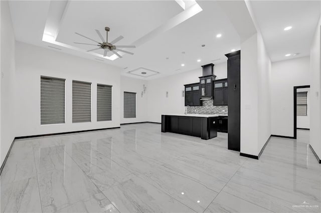 4120 Wisteria Ave, Mcallen, TX 78504 - unfurnished living room with a ceiling fan, a tray ceiling, baseboards, recessed lighting, and light marble finish flooring