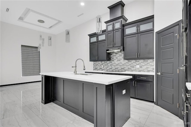 4120 Wisteria Ave, Mcallen, TX 78504 - kitchen featuring light marble finish flooring, a sink, tasteful backsplash, light countertops, and a center island with sink