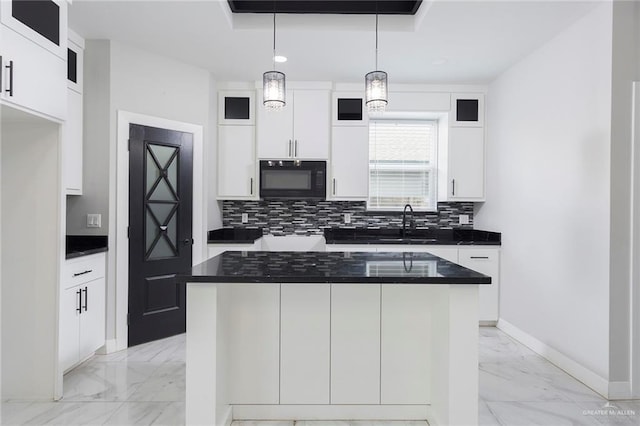 kitchen featuring tasteful backsplash, white cabinets, a kitchen island, and pendant lighting