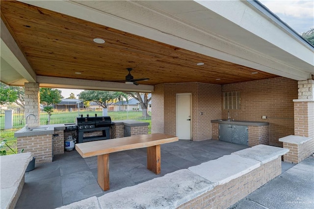 view of patio with an outdoor kitchen, area for grilling, sink, and ceiling fan