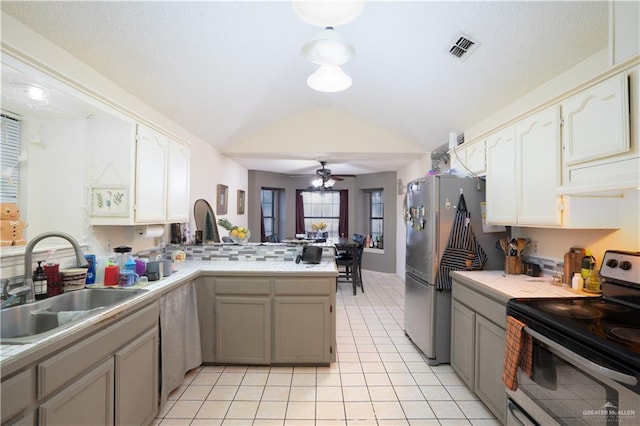 kitchen featuring kitchen peninsula, ceiling fan, appliances with stainless steel finishes, light tile patterned flooring, and sink