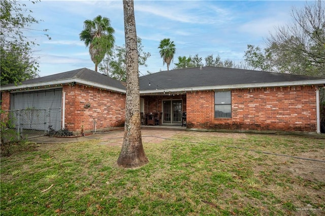 rear view of house with a yard and a garage