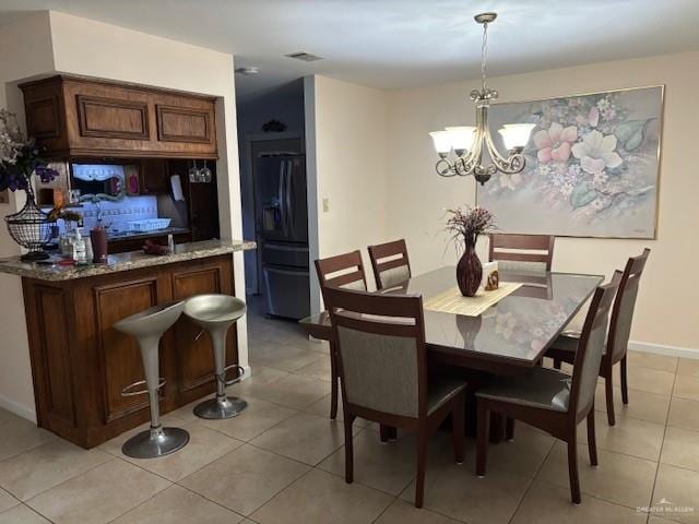 tiled dining space featuring an inviting chandelier