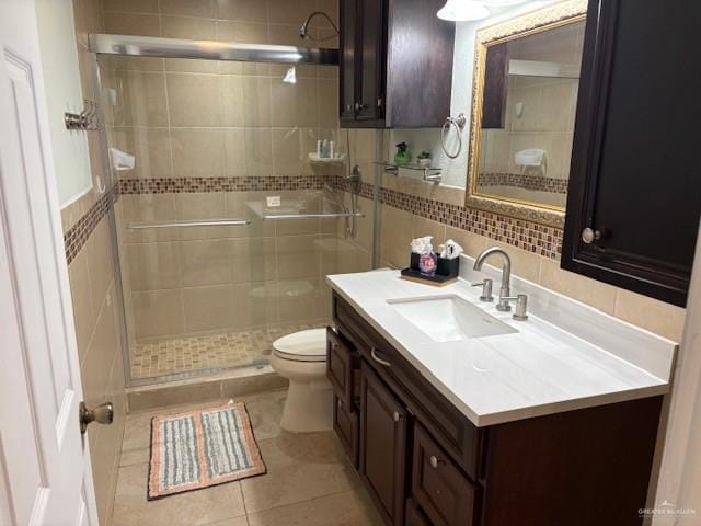 bathroom featuring walk in shower, vanity, toilet, and tile walls