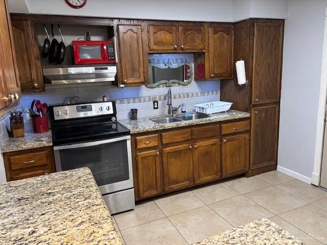 kitchen featuring light stone countertops, sink, stainless steel electric range, and exhaust hood