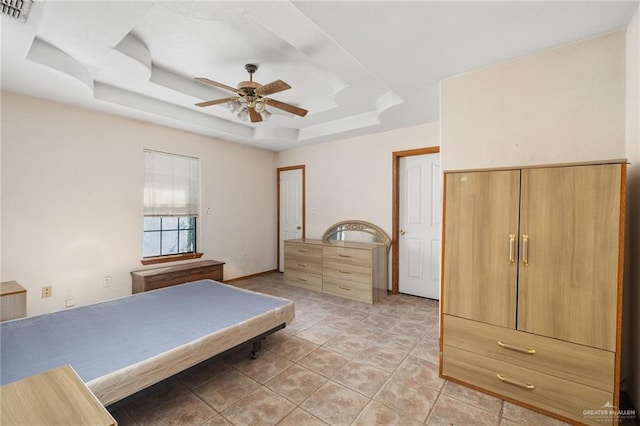 bedroom with a raised ceiling, ceiling fan, and light tile patterned floors