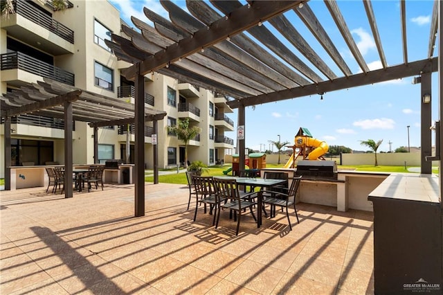 813 Travis St Unit 419, Mission, TX 78572 - view of patio / terrace featuring a pergola, area for grilling, an outdoor kitchen, exterior bar, and outdoor dining space