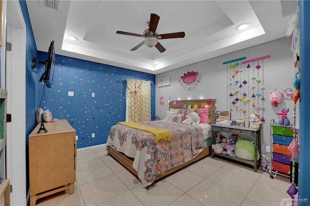 bedroom featuring a tray ceiling, ceiling fan, and light tile patterned flooring