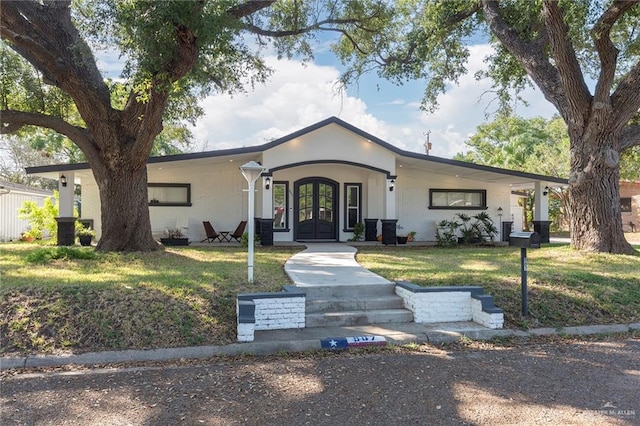 ranch-style house with a front yard and french doors