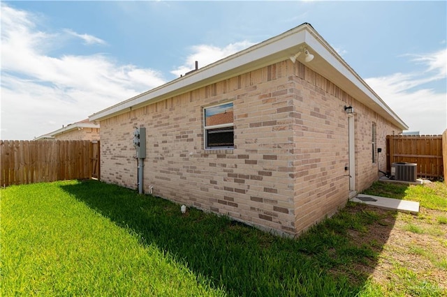 view of side of home featuring a yard and central AC unit