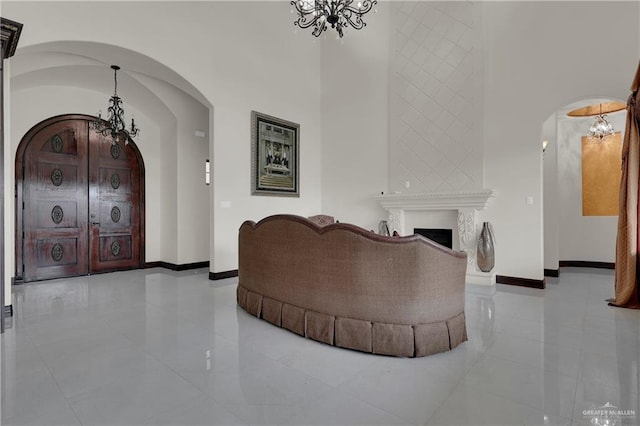 living room with light tile patterned floors, a high ceiling, and an inviting chandelier