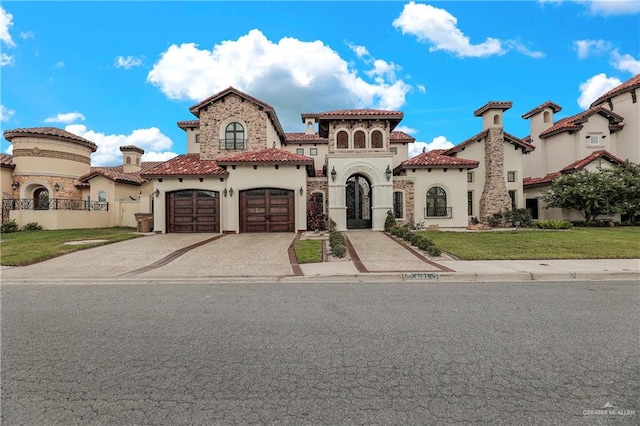 mediterranean / spanish home with a front lawn and a garage