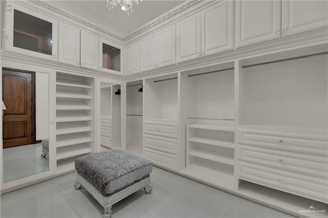 spacious closet with light tile patterned floors and a chandelier