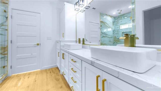 bathroom with an enclosed shower, vanity, and wood-type flooring