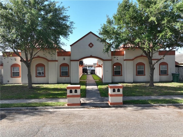 mediterranean / spanish-style home featuring a front yard