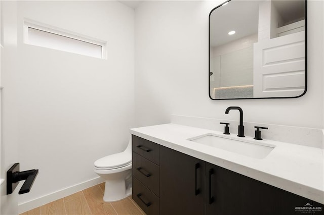 bathroom featuring vanity, wood-type flooring, and toilet