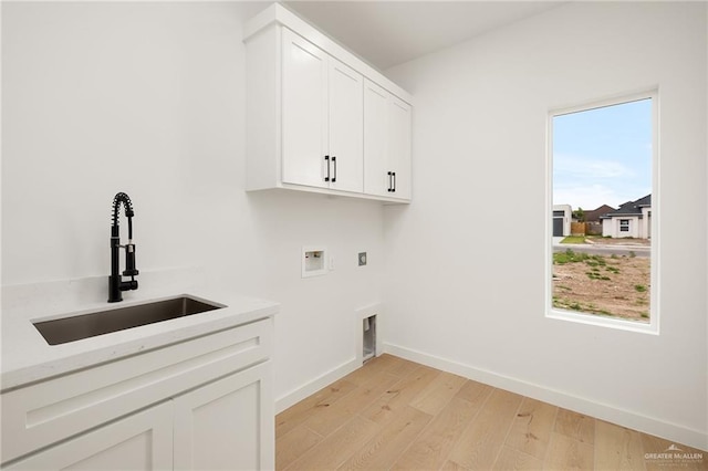 washroom featuring sink, electric dryer hookup, cabinets, washer hookup, and light wood-type flooring