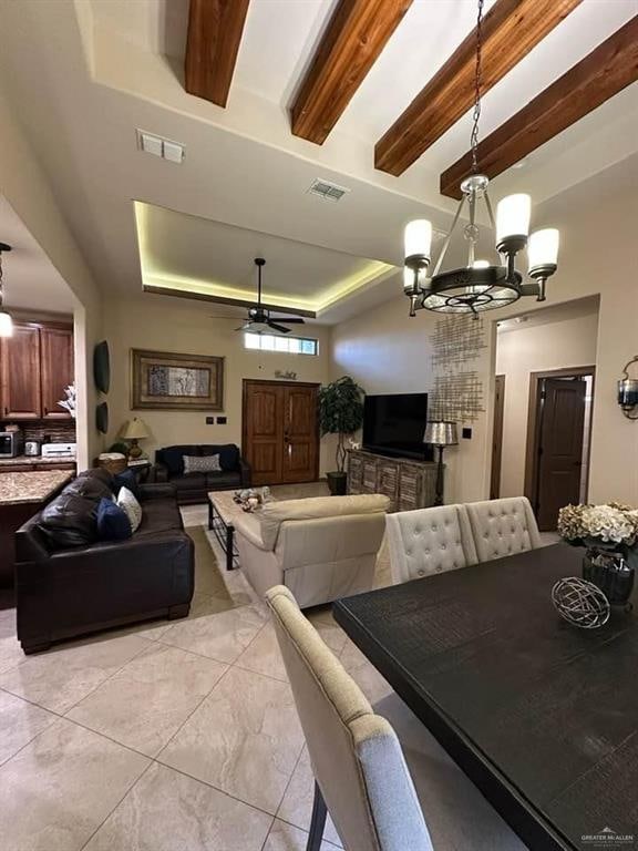 tiled dining room with beamed ceiling, ceiling fan with notable chandelier, and a raised ceiling