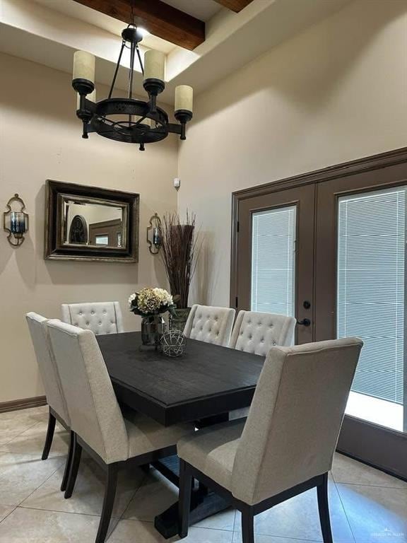 tiled dining room with beamed ceiling, french doors, and a chandelier