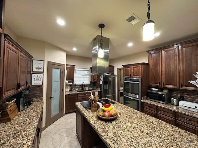 kitchen with tasteful backsplash, pendant lighting, and appliances with stainless steel finishes