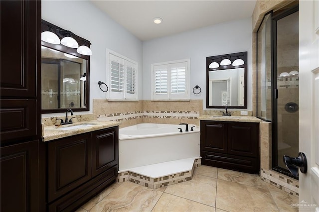 full bath with a shower stall, a bath, tile patterned floors, and two vanities