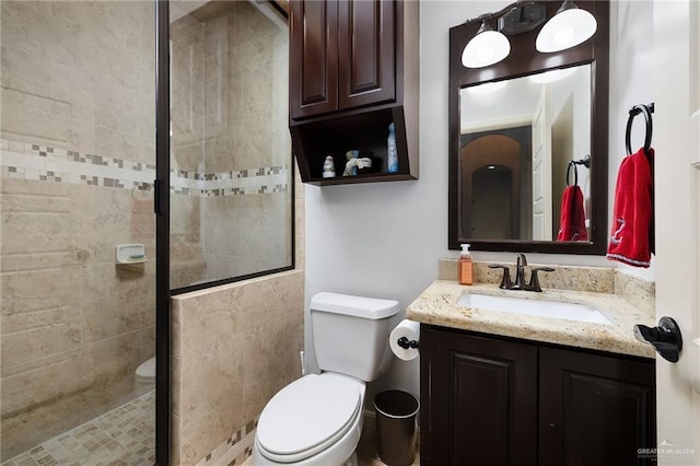 full bathroom featuring toilet, a shower stall, and vanity