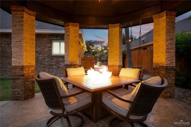 dining area featuring decorative columns and concrete flooring