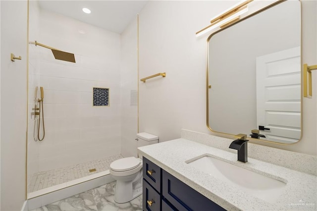 bathroom with vanity, toilet, and a tile shower