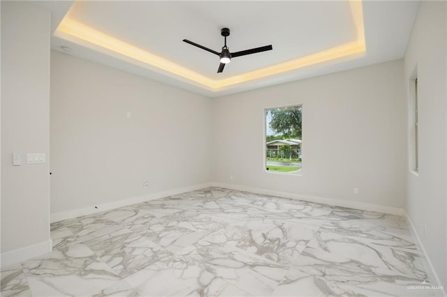 unfurnished room featuring a tray ceiling and ceiling fan