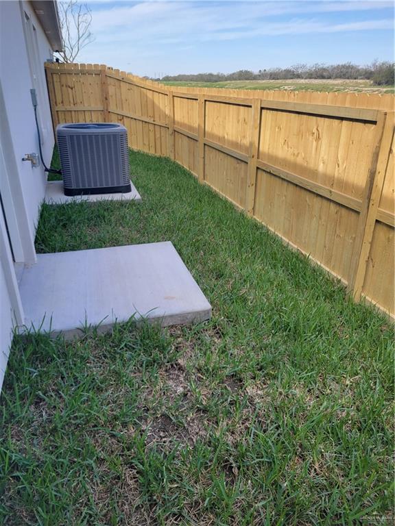 view of yard with fence and central air condition unit