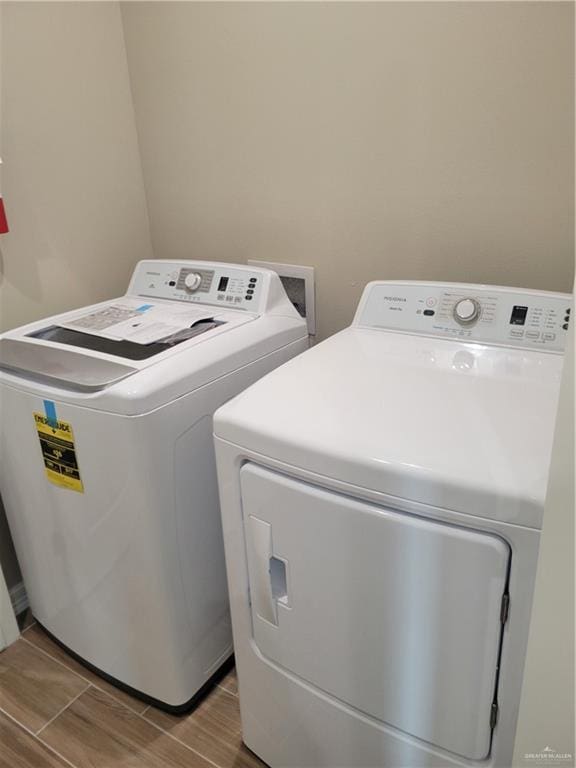 laundry area featuring laundry area, wood tiled floor, and washer and dryer