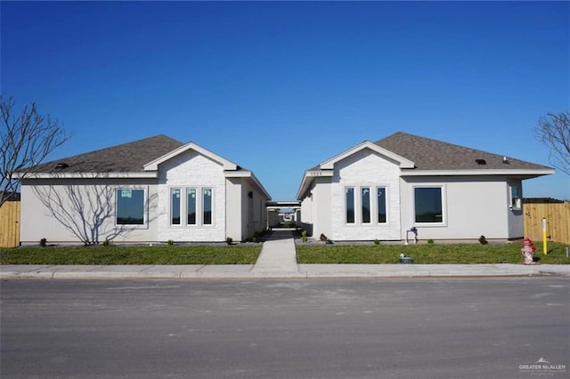 view of front of house featuring roof with shingles and fence