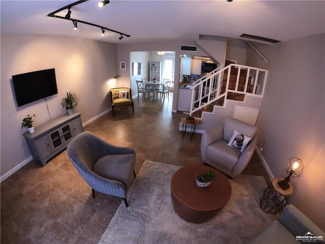 living room featuring stairs, baseboards, rail lighting, and ceiling fan