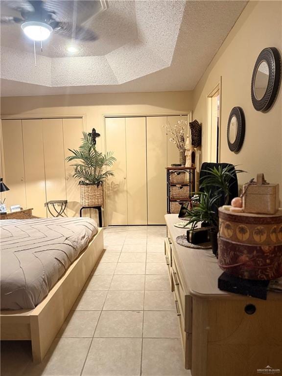 2612 Ashley Dr, Pharr, TX 78577 - bedroom with two closets, light tile patterned floors, a textured ceiling, and a ceiling fan