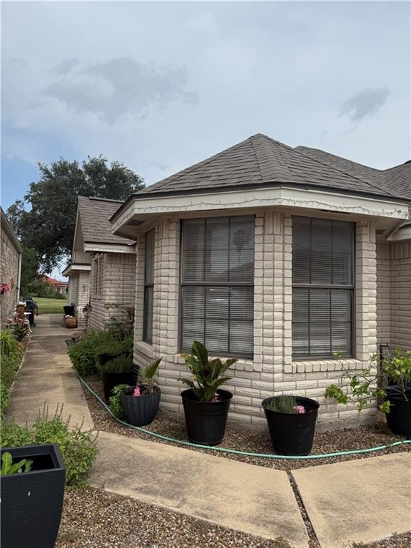 2612 Ashley Dr, Pharr, TX 78577 - view of side of property featuring roof with shingles and brick siding