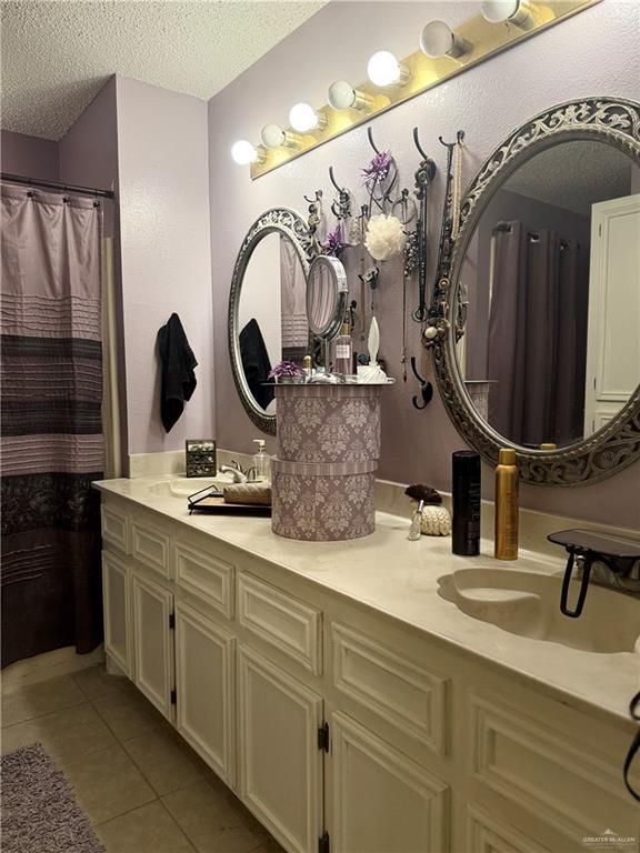 2612 Ashley Dr, Pharr, TX 78577 - bathroom with a textured ceiling, tile patterned flooring, and double vanity