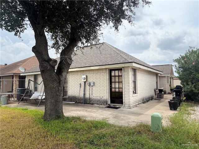 2612 Ashley Dr, Pharr, TX 78577 - back of property featuring a patio area, brick siding, and roof with shingles