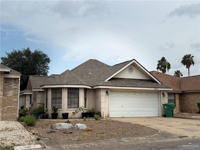 2612 Ashley Dr, Pharr, TX 78577 - view of front facade with a garage, driveway, brick siding, and roof with shingles