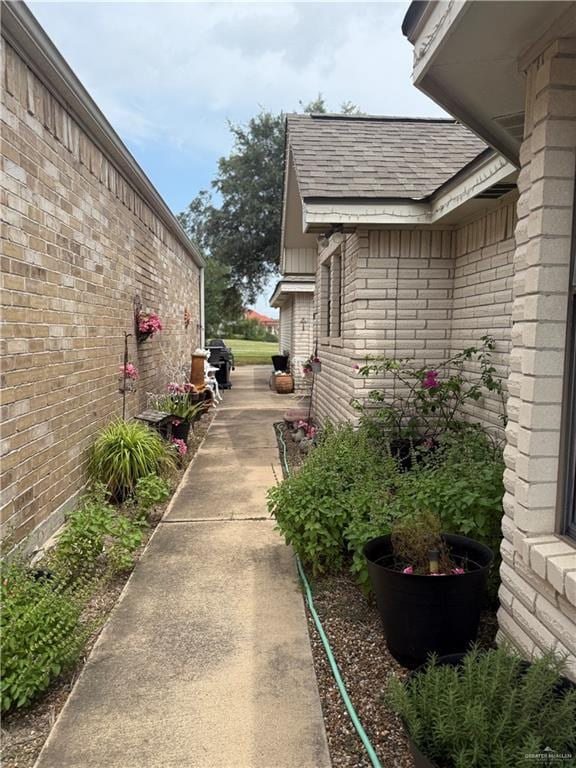 2612 Ashley Dr, Pharr, TX 78577 - view of side of property featuring roof with shingles and brick siding