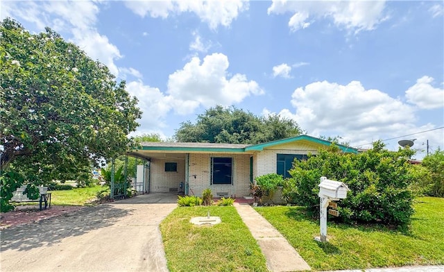 814 N Pino St, Weslaco, TX 78596 - view of front of home with brick siding, driveway, a front lawn, and a carport
