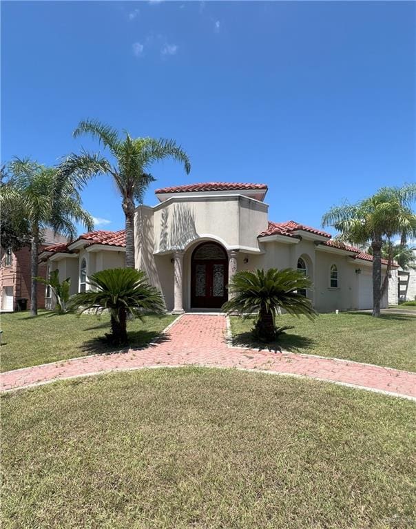 mediterranean / spanish-style house featuring french doors and a front lawn