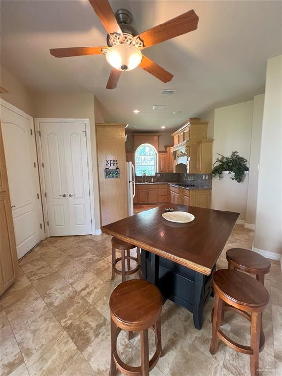 dining room with ceiling fan and sink