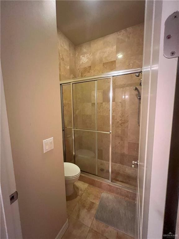 bathroom with tile patterned floors, toilet, and walk in shower