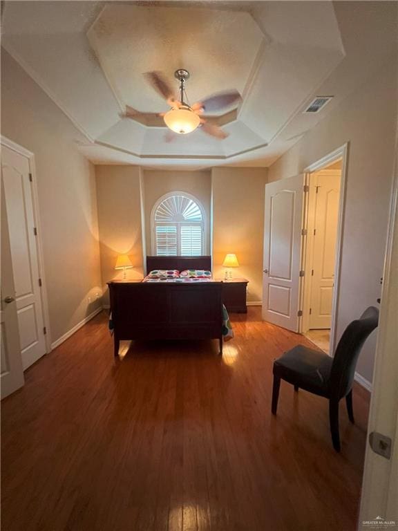 bedroom featuring wood-type flooring, a raised ceiling, and ceiling fan