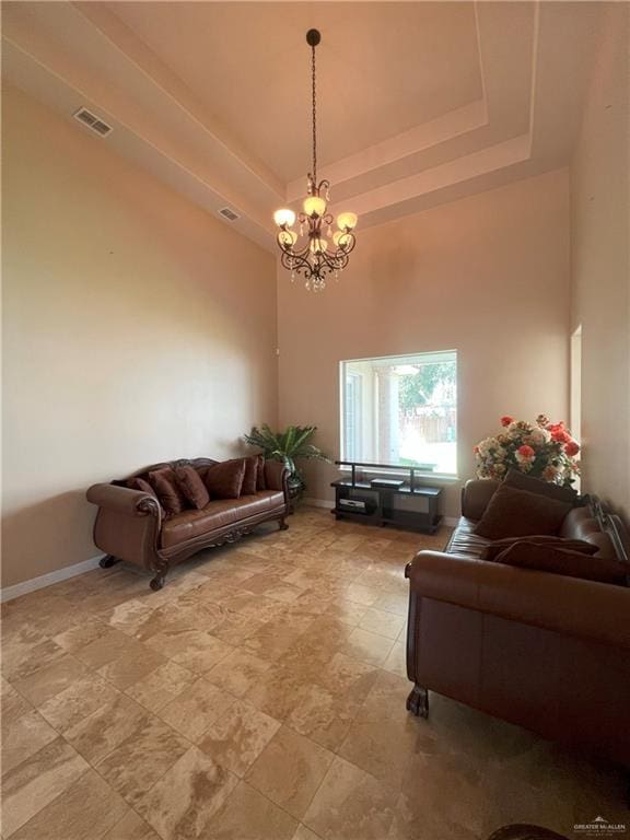 living room with a raised ceiling, a towering ceiling, and an inviting chandelier